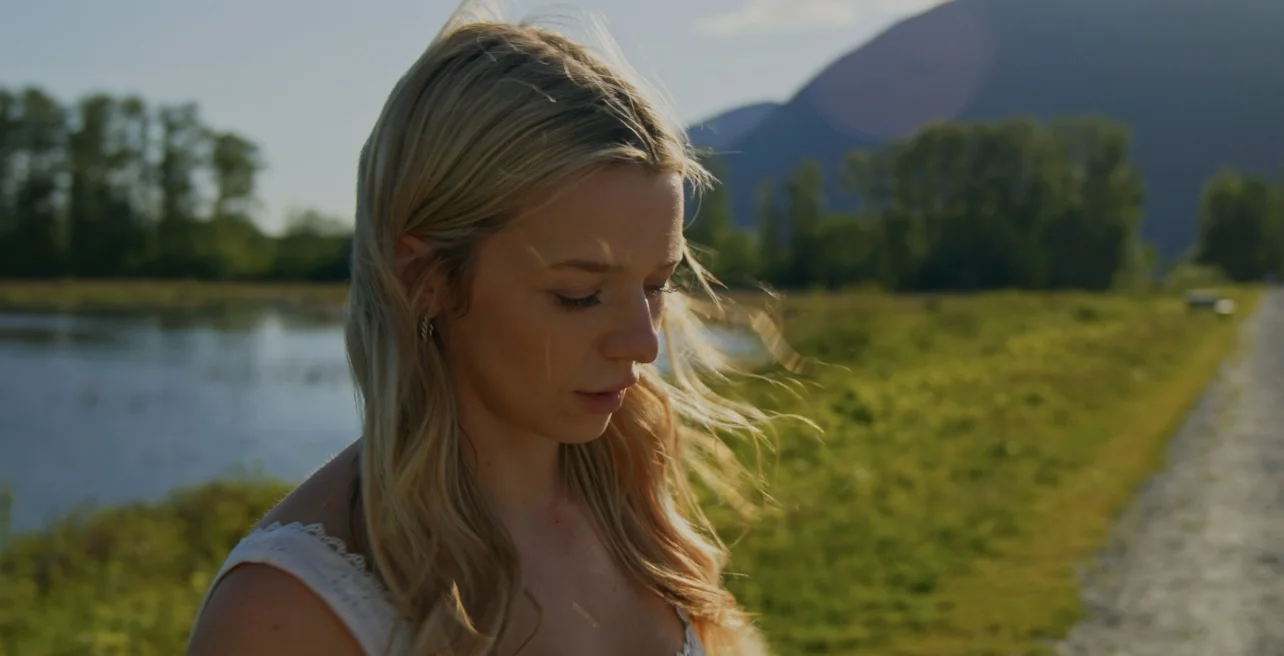 Emily Nelson beside a river with mountains in the distance